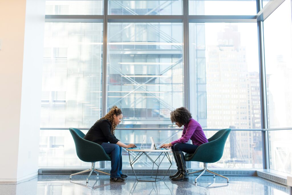 A photograph of two female Product Managers collaborating and working together.