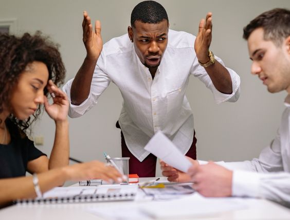 A photograph capturing a Product Manager engaged in a heated discussion with colleagues, indicating conflict with the Development team.